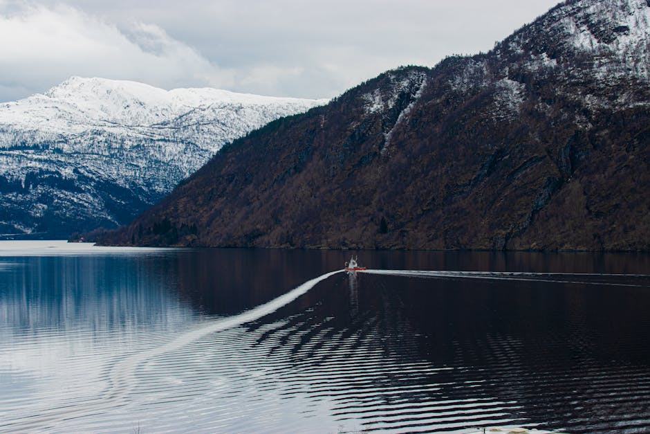 Fiordos noruegos con montañas nevadas reflejadas en el agua
